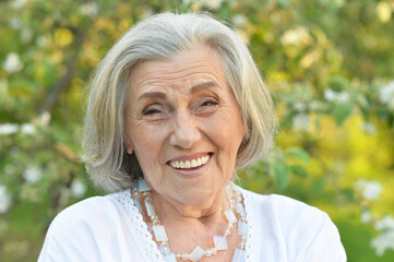 Close up portrait of senior beautiful woman in spring park