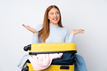 Traveler woman with a suitcase full of clothes with surprise facial expression