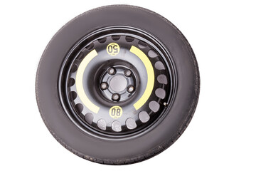 Fototapeta premium Full size black car spare tire with yellow marking and signs on a white background in a photo studio. Sale of spare summer tires or seasonal replacement in a car dismantling workshop.