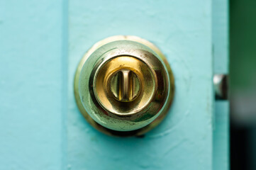 Door lock of an old wooden door of gold color close-up