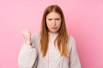 Fototapeta premium Young redhead woman over isolated pink background with angry gesture