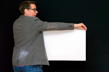 Side view image of caucasian Business man holding a blank banner isolated on black background