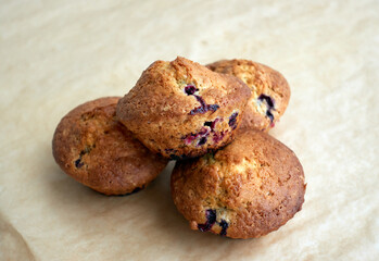 Berry homemade muffins on a light crafted paper. Perfect tasty pastry for breakfasts, snacks, lunch or teatime. Homemade sweets cooking and baking concept.