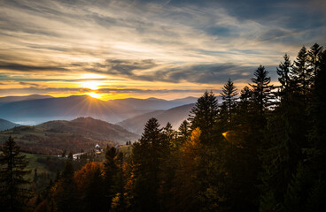 Bright colorful sunrise in mountains with smoke and dramatic bright sky