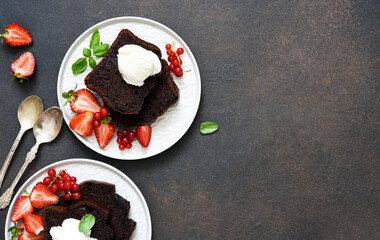 Chocolate cake slices on the plate on a concrete dark background. View from above. Brownie pie.