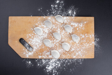 Dumplings pattern on a wooden board. Food concept.