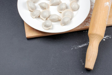 Dumplings in a white plate on a black background. Food concept. Copy space for design.