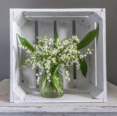 Still life with a bouquet of freshly cut lilies of the valley in the interior. Spring flowers.