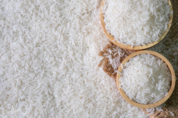 White rice seed in Brown wooden bowl on Rice background.