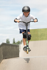 The boy jumps on a scooter. © rades