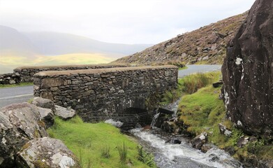 Fototapeta na wymiar A bridge on the way up Conor Pass which is a high narrow road over the mountains in the centre of the Dingle Peninsula, in County Kerry, Ireland.