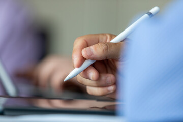 Close up of hand holding pen in meeting