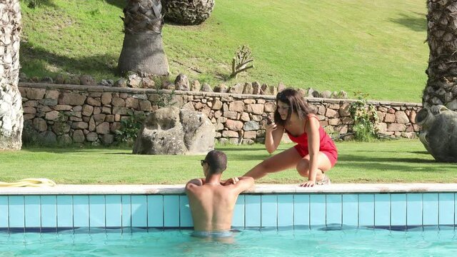 Video in 4k di  un ragazza vestita di rosso che riprende un razza moro dentro una piscina in un villaggio turistico  