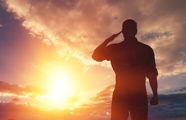 Young military soldier man silhouette on sunset background
