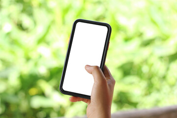 Cropped shot view of woman's hands holding smart phone with blank copy space screen for your text message or information content. Female’s hand holding smart phone with green blur background.
