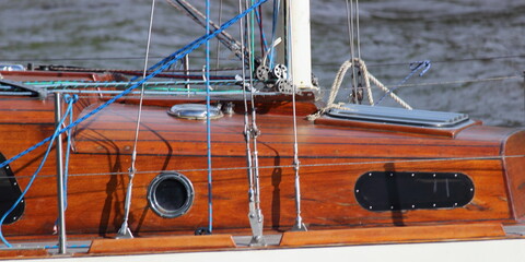 Vintage sailing yacht floating on the water background on a summer day, close up view on wooden the ship's wheelhouse, yachting lifestyle outdoor recreation picture for header © Ilya