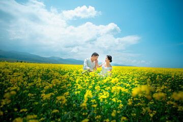 Fototapeta premium Couple and wedding dress in rape flower sea.