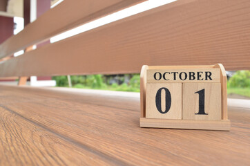 October 1, Number cube with wooden balcony background.