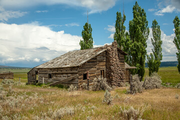 An abandoned homestead building with a rock fireplace and chimney, near Post, Oregon.