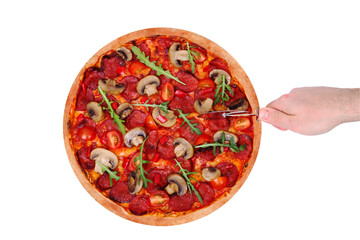 The man cuts the pizza hot with spicy salami, arugula, cherry tomatoes, mushrooms and texas spice mix, with a pizza cutter. Top view, isolated on white background