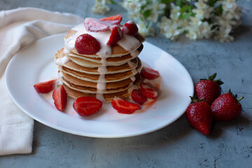 pancakes with strawberry and flowers on a background
