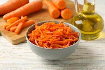 Composition with carrot salad on white wooden table. Cooking korean carrot