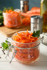 Composition with tasty carrot salad on white wooden background. Korean carrot
