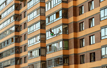 Worker - a climber washes windows on a high-rise building