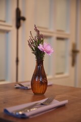 Vase with wildflowers on the table. Table setting in a restaurant, cafe.