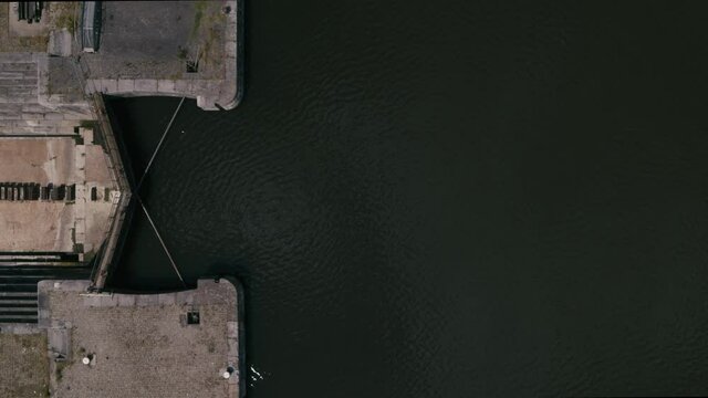 Graphical topshot coming from above the water revealing a sluice and abandoned shipyard with an old lightship that used to sail the Northsea. Inspire2 X7 12mm prores
