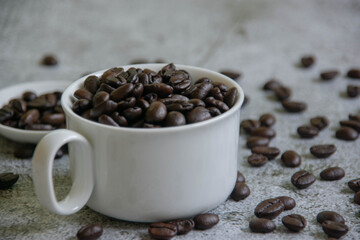 
White coffee cups and roasted coffee beans On the cement background