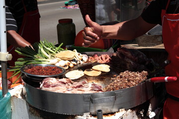 Street Food rich Tacos with toppings and thumbs up in downtown Mexico city