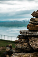 Pile of stones on the hill with view to the Tromso area, northern Norway. Fiord with mountains and sea in the background. Climbing mountain.