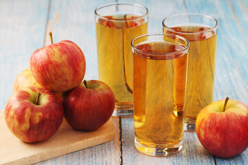 Glasses with apple juice and ripe apples