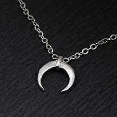 Fototapeta na wymiar Silver crescent moon pendant with chain