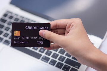 Flat lay man using credit card for online shopping on keyboard computer background