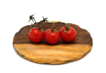 Several red ripe tomatoes on a cutting board on a light background. Natural product. Natural color. Close-up.