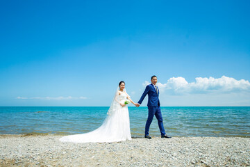 Fototapeta na wymiar Couples take wedding photos by the beach and lake to propose.