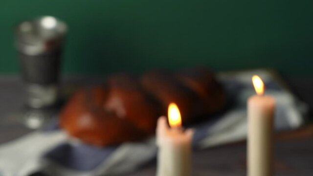 Shabbat Shalom. Challah bread, shabbat wine and candles on wooden table.