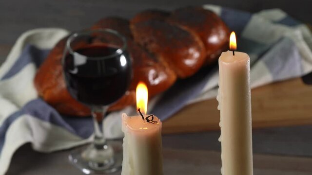 Shabbat Shalom. Challah bread, shabbat wine and candles on wooden table.