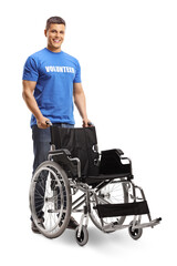 Young male volunteer standing with an empty wheelchair
