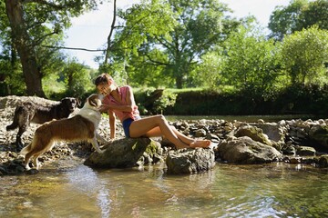 Portrait jeune femme au bord de la rivière avec son chien (border collie) - nature vacances voyage - détente zen bien-être