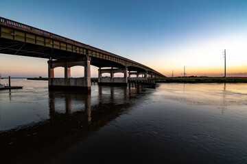 Fototapeta na wymiar Sunset over the US Highway 17 bridge crossing the river at Darien Georgia
