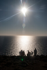 rays of the setting sun, sea, people