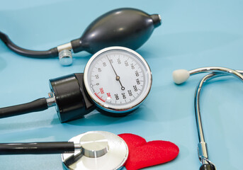 blood pressure monitor, stethoscope and heart isolated on a blue background. The concept of health, the measurement of pressure, heart disease