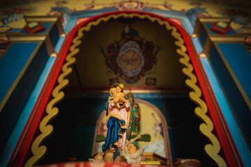 Fototapeta na wymiar Saint with baby Jesus on his lap in colorful temple.