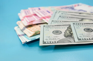 Dollars and hryvnias on a blue background. Much money. Close-up.