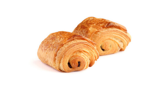 Two french traditional croissants with  two pieces of dark chocolate in the centre called Petit pain au chocolat  isolated on white background.