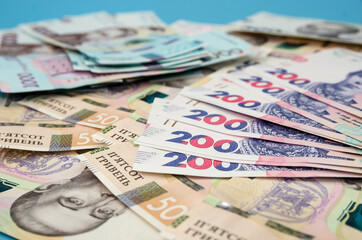 Ukrainian hryvnia on a blue background. Much money.