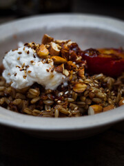 Wholefoods healthy grains, nuts and seeds granola breakfast in rustic natural light setting and custom ceramics